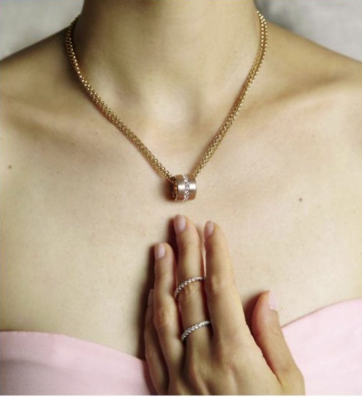Diamond pendant necklace worn with slim diamond rings