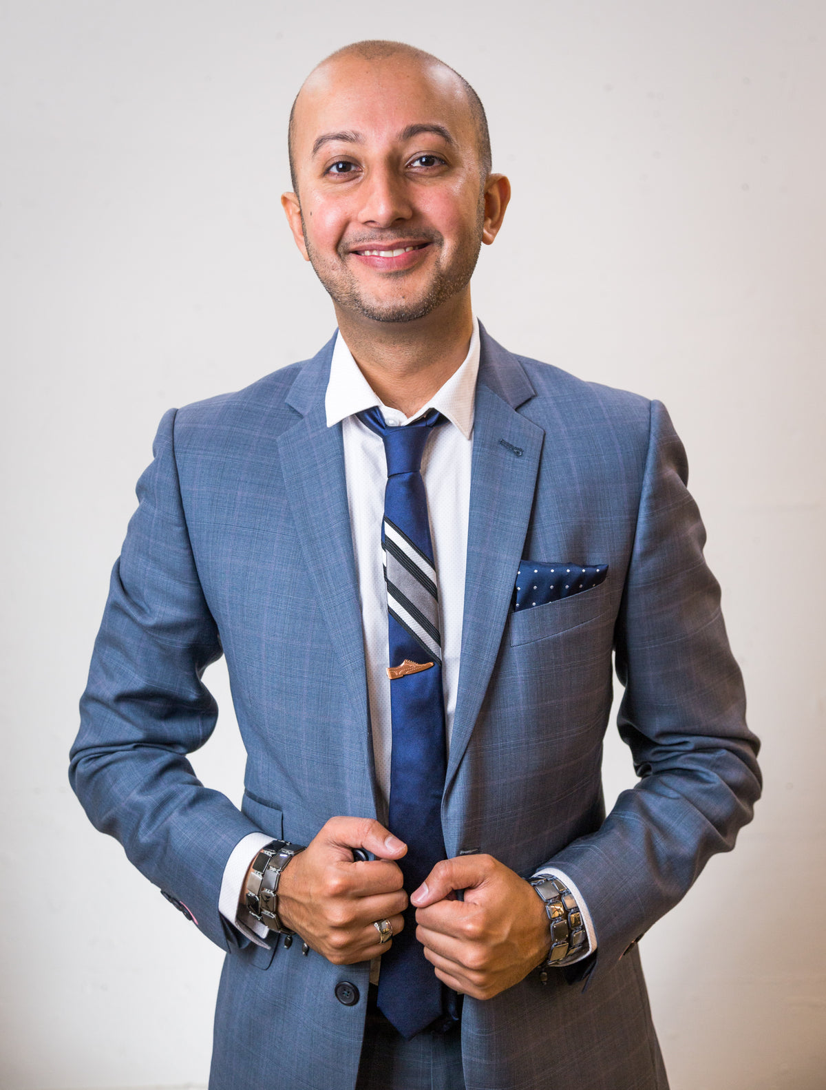 Portrait of founder Vinay Krishnani in a blue suit and striped tie